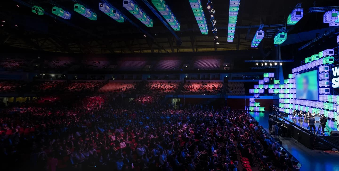 A crowded arena under stage lighting
